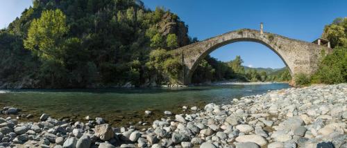 a stone bridge over a river with rocks at Ca’d’ambra in Groscavallo