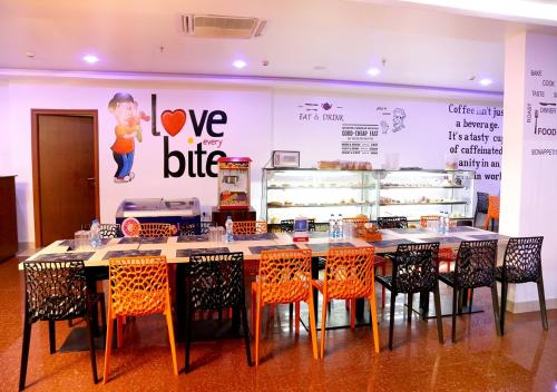 a dining room with a table and chairs and a bakery at Triguna Clarks Inn Kurnool in Kurnool