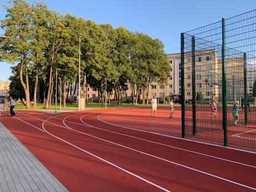 a group of people playing tennis on a tennis court at Excelent apartment with garden and free parking in Rīga