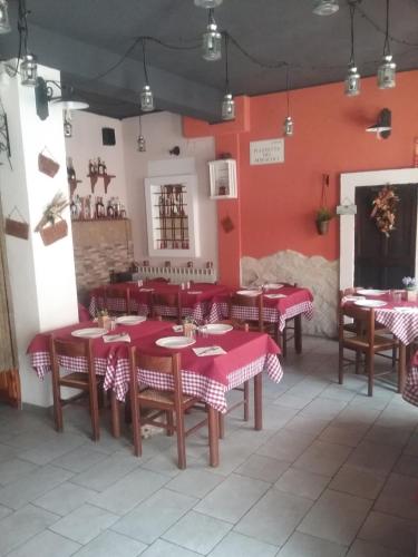 un restaurante con mesas y sillas rojas y blancas en Locanda dei miracoli, en Pizzoli