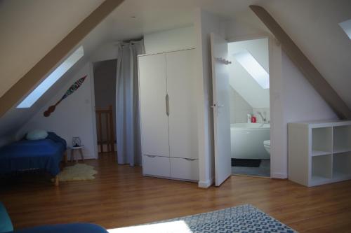a attic room with a white cabinet and a bathroom at Gîte la Briantaise in Saint Malo