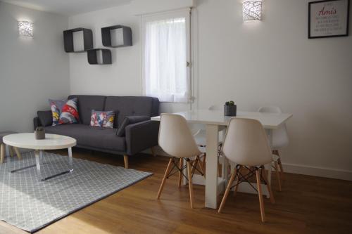 a living room with a couch and a table and chairs at Gîte la Briantaise in Saint Malo