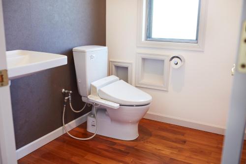 a bathroom with a white toilet and a sink at Resort villa miko in Oshima