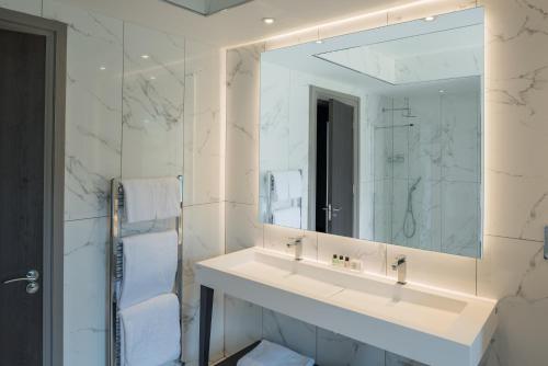 a white bathroom with a sink and a mirror at Dalmeny Park House Hotel in Barrhead