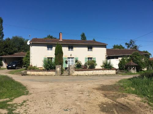 a white house with a road in front of it at La Maison d'Olives in Nouic