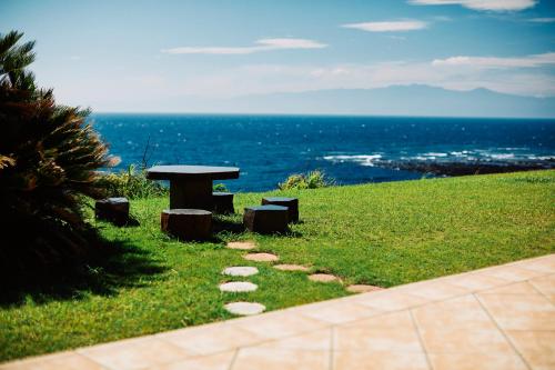 a picnic table and bench on a hill with the ocean at Resort villa miko in Oshima