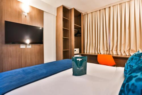 a hotel room with a bed and a tv at San Diego Express Barro Preto in Belo Horizonte