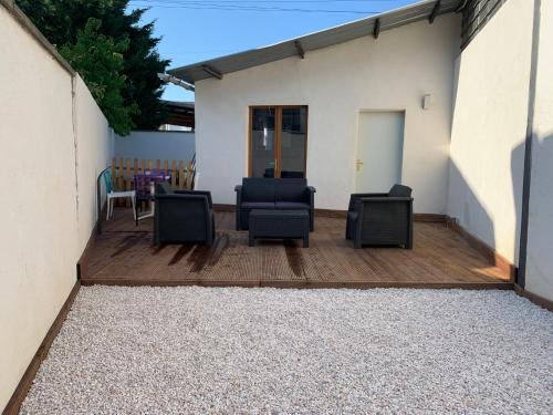 a patio with chairs on a wooden deck at Manifique Maison T2 50m2 Atypique wifi & parking privée in Oullins