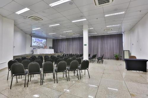 a conference room with chairs and a screen in it at San Diego Express Barro Preto in Belo Horizonte