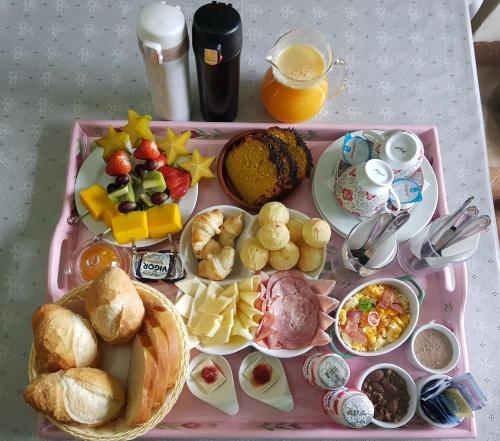 een roze dienblad gevuld met een dienblad met ontbijtproducten bij POUSADA NICO ON THE HILL in Monte Verde