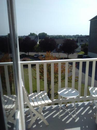 un fauteuil à bascule blanc assis sur un balcon dans l'établissement Les Couesnons, à Pontorson