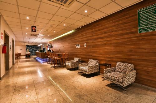 a waiting room with chairs and a table and a bar at San Diego Express Barro Preto in Belo Horizonte