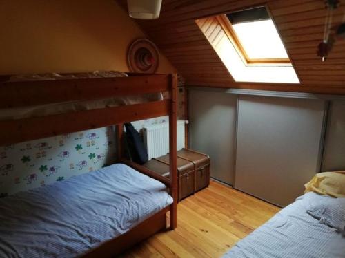 a bedroom with two bunk beds and a window at Maison typique pleine de charme Peyrusse Cantal in Peyrusse