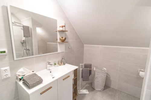 a white bathroom with a sink and a mirror at Lackenbauer in Muggenau