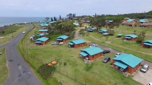 an aerial view of a village with houses and the ocean at Port Edward Holiday Resort in Port Edward