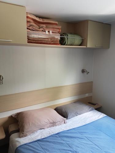 a bedroom with a bed with a shelf above it at Mobil-home 75 au Camping Le Rioumajou in Bourisp