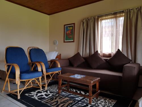 a living room with a couch and two chairs at Port Edward Holiday Resort in Port Edward