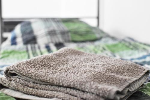 a pile of towels sitting on top of a bed at Praktisches Apartment mit Flatscreen TV in Leverkusen