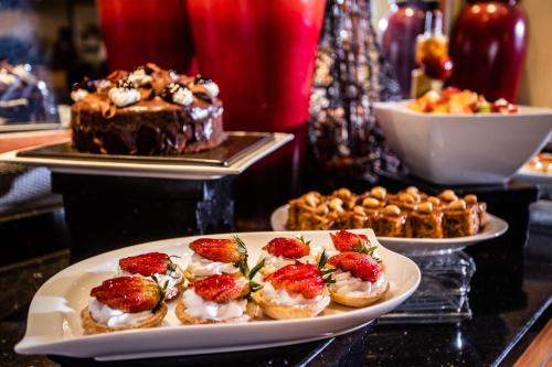 a table topped with plates of desserts and cakes at Southern Sun Ridgeway Lusaka in Lusaka