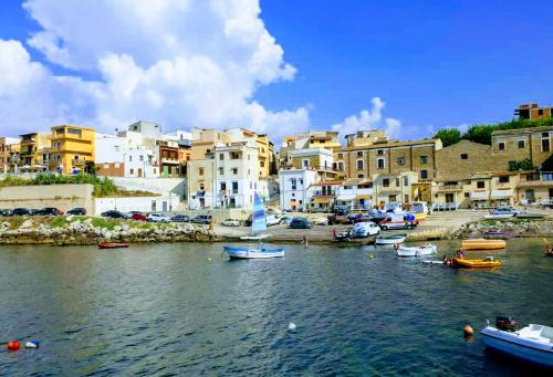 a group of boats in a body of water with buildings at Summer Dream LA CASA SUL MARE in Trappeto