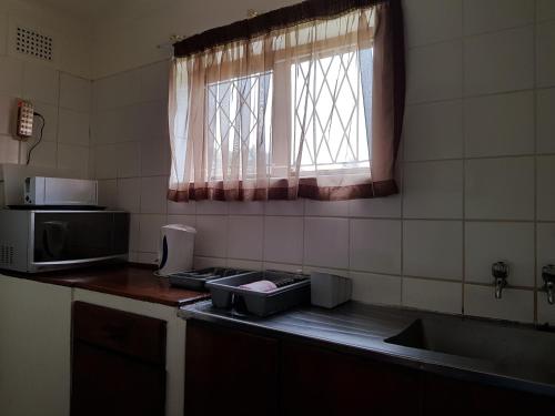 a kitchen with a counter top with a sink and a window at Port Edward Holiday Resort in Port Edward