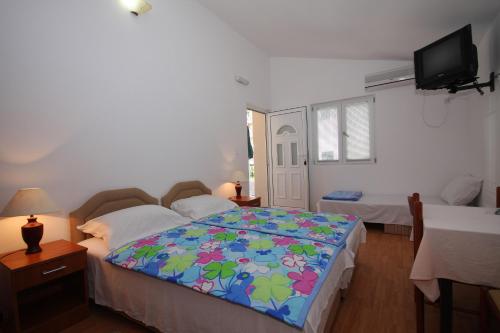 a bedroom with a bed with a colorful blanket at Apartments Raičević in Budva