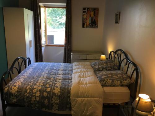 - une chambre avec 2 lits et une fenêtre dans l'établissement FORGEROC, à Saint-Cirq-Lapopie