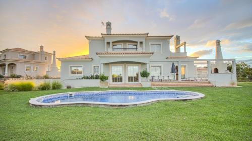 a large house with a swimming pool in the yard at Villas @ Quinta do Vale Golfe in Castro Marim