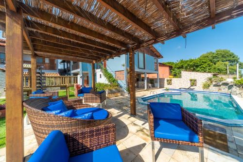 a patio with chairs and a swimming pool at Pousada Blue Viking in Praia do Frances