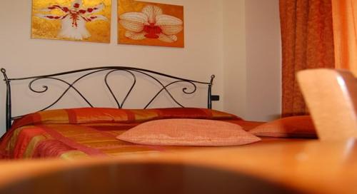 a bedroom with a bed with red and orange pillows at B&B La Ca Vecia in Soragna