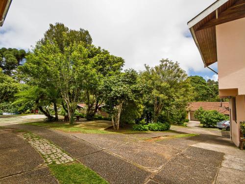 a driveway in a yard with trees and a house at Pousada Recanto São Benedito in Campos do Jordão