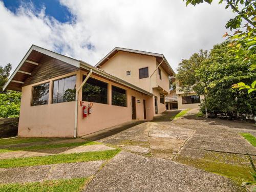 a house with a driveway in front of it at Pousada Recanto São Benedito in Campos do Jordão