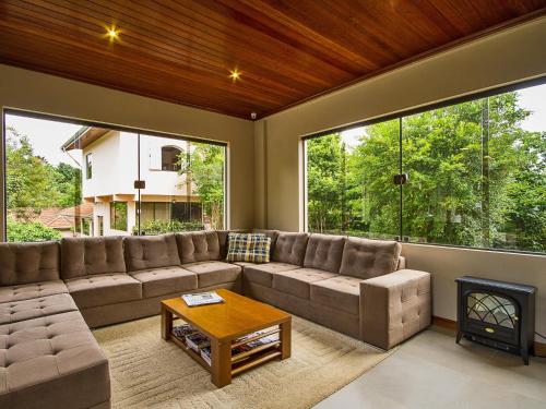 a living room with a couch and a fireplace at Pousada Recanto São Benedito in Campos do Jordão