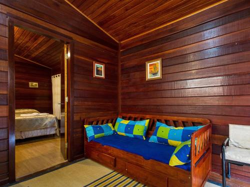 a bedroom with a bed with blue and yellow pillows at Pousada Recanto São Benedito in Campos do Jordão