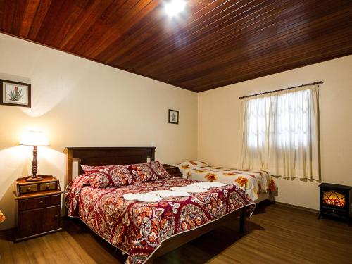 a bedroom with a bed and a window at Pousada Recanto São Benedito in Campos do Jordão