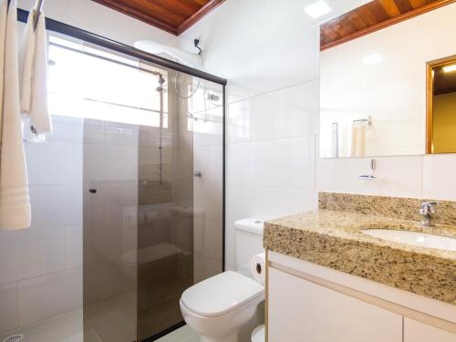 a bathroom with a toilet sink and a shower at Pousada Recanto São Benedito in Campos do Jordão