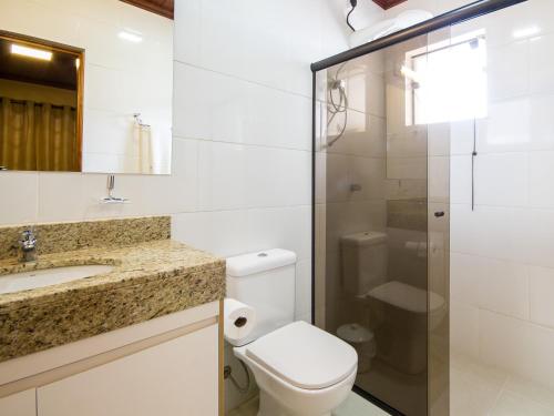 a bathroom with a toilet and a sink and a shower at Pousada Recanto São Benedito in Campos do Jordão