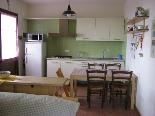 a kitchen with a table and chairs and a kitchen with a refrigerator at Belvedere Vacanze Toscana in Lamporecchio