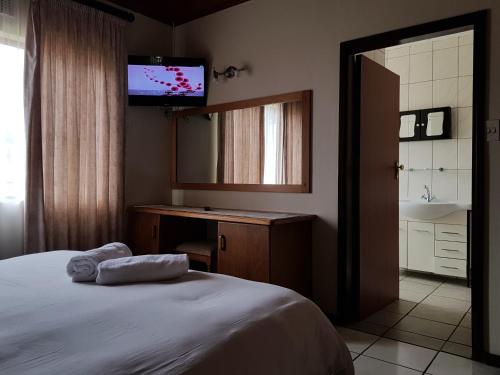 a bedroom with a bed with a mirror and a television at Port Edward Holiday Resort in Port Edward