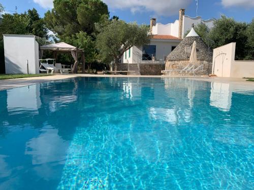 a large swimming pool with blue water at Residenza Lippolis in Castellana Grotte