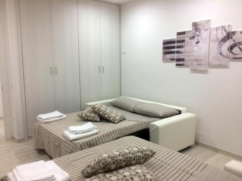 a room with two beds and a couch and a painting at La casa di Donatella in Naples