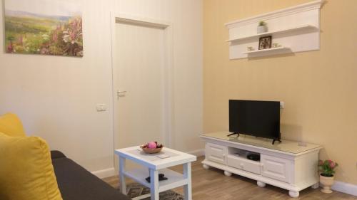 sala de estar con TV en un tocador con mesa en Enjoy Apartment, en Timisoara
