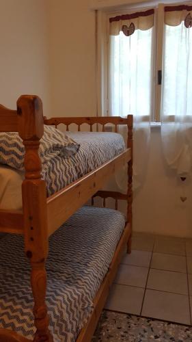 two bunk beds in a room with a window at CROTTO CARACO APPARTAMENTI BUNGALOW CHALET in Porlezza