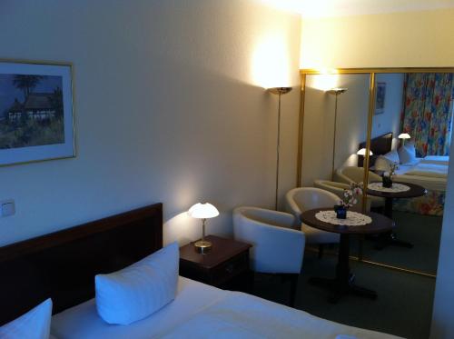 グレーヴェスミューレンにあるPension Sebaのベッドと鏡が備わるホテルルーム