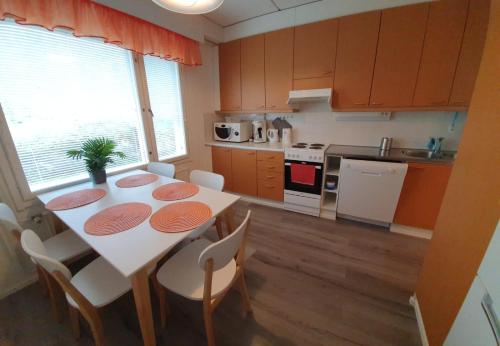 una cocina con mesa y sillas y una cocina con mesa y sillón. en Hamina Orange Apartments Ilves en Hamina
