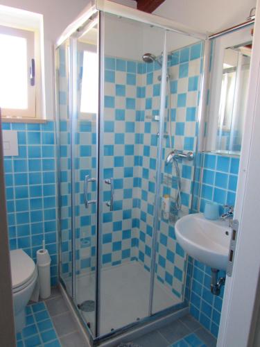 a blue tiled bathroom with a shower and a sink at Antico Vicolo in Scilla