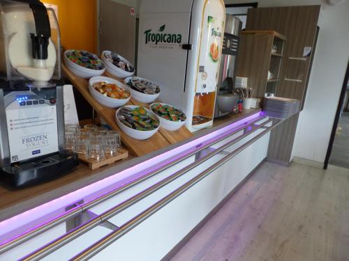a food counter with bowls of food on display at Kyriad Toulouse Sud - Roques in Roques Sur Garonne