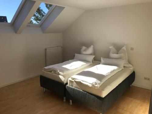 two twin beds in a room with a window at Wendlers Ferienwohnungen #7 in Schwaig bei Nürnberg
