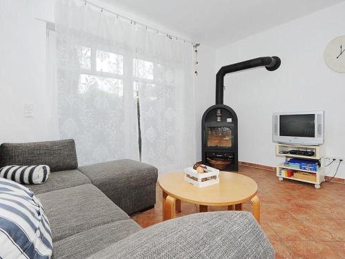 ein Wohnzimmer mit einem Sofa, einem Tisch und einem TV in der Unterkunft Haus Kiebitznuest - Langeoog in Langeoog