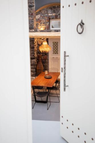 a dining room with a table and a dining room door at Aleria Luxury Cave Santorini in Éxo Goniá